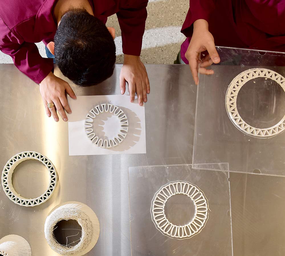 researchers examining 3D printed pieces for prototype structure