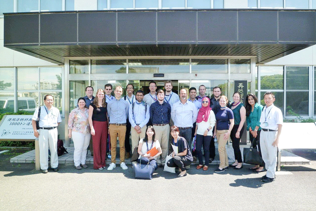 Group of graduate students and staff from NSSPI and NFE posing in front of a building.