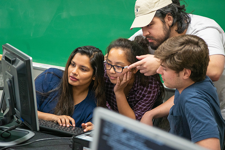 Group of four students, supercomputer team working together.