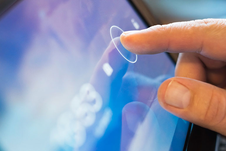 Finger touching the screen of a tablet