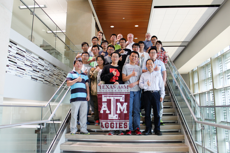 Harbin Engineering University Students Taking A Picture Of A Flag With Words of Texas A&M University ATM Aggies