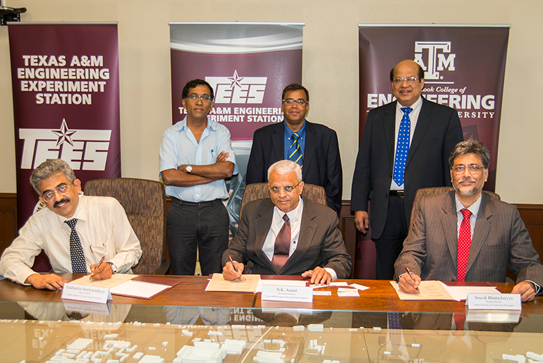 Representatives From Texas A&amp;M University’s Dwight Look College of Engineering and the Indian Institute of Technology Kharagpur Signing With Banners With Words Of Texas A&amp;M Engineering Experiment Station TEES In The Background
