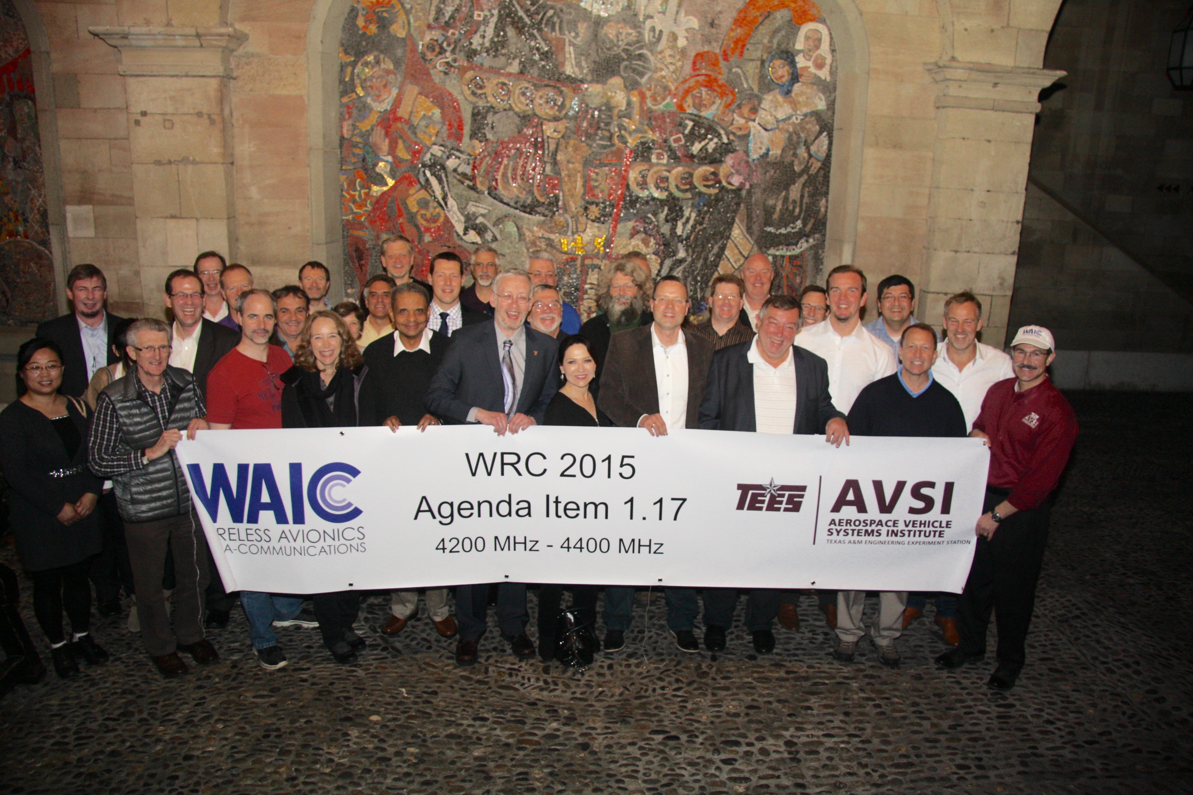 AVSI Wireless Avionics Intra-Communications (WAIC) Holding A Banner With Words of WAIC WRC 2015 Agenda Item 1.17 4200 MHz - 4400 MHz TEES AVSI Aerospace Vehicle Systems Institute