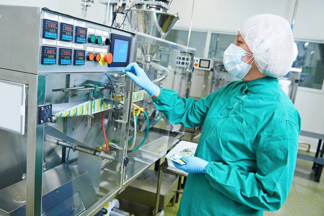 Researcher in a lab wearing protective gown, gloves and mask