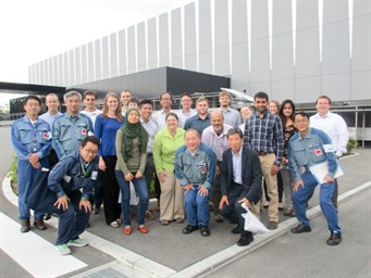 Image of a group of individuals posing in front of a building