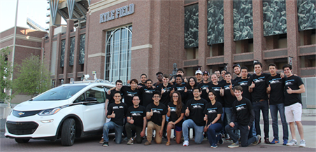 Texas A&amp;M AutoDrive Challenge team posing with their car in front of the Kyle Field