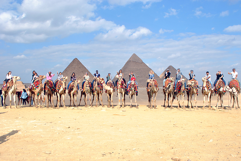 Group of individuals riding on top of camels