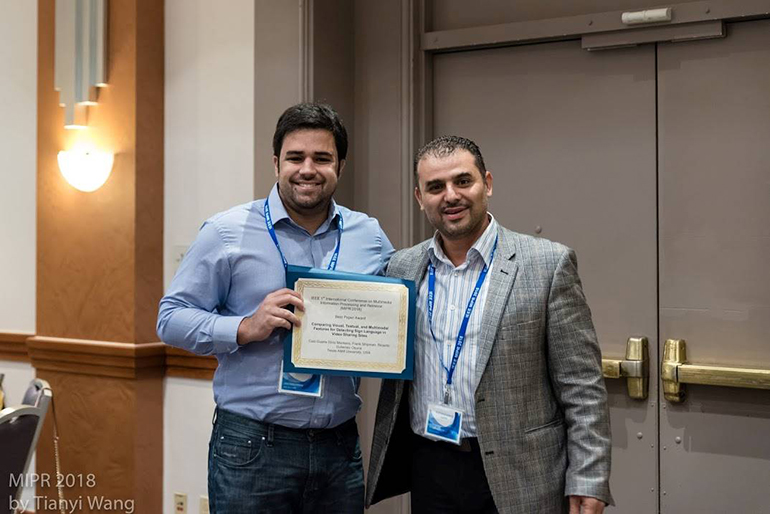 Caio Monteiro and a man posing with the Best Paper Award certificate.
