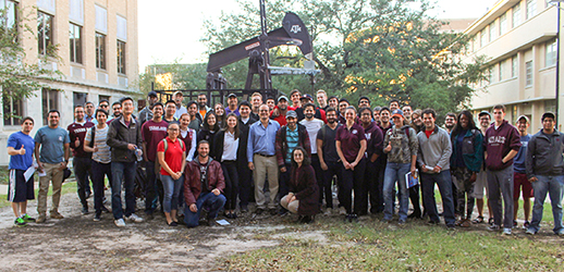 Dr. Ibere Alves with a group of students at the oil pump on TAMU campus