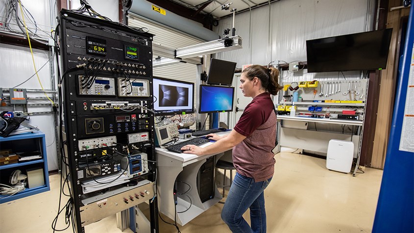 A woman working on a machine in the Aero thermo lab
