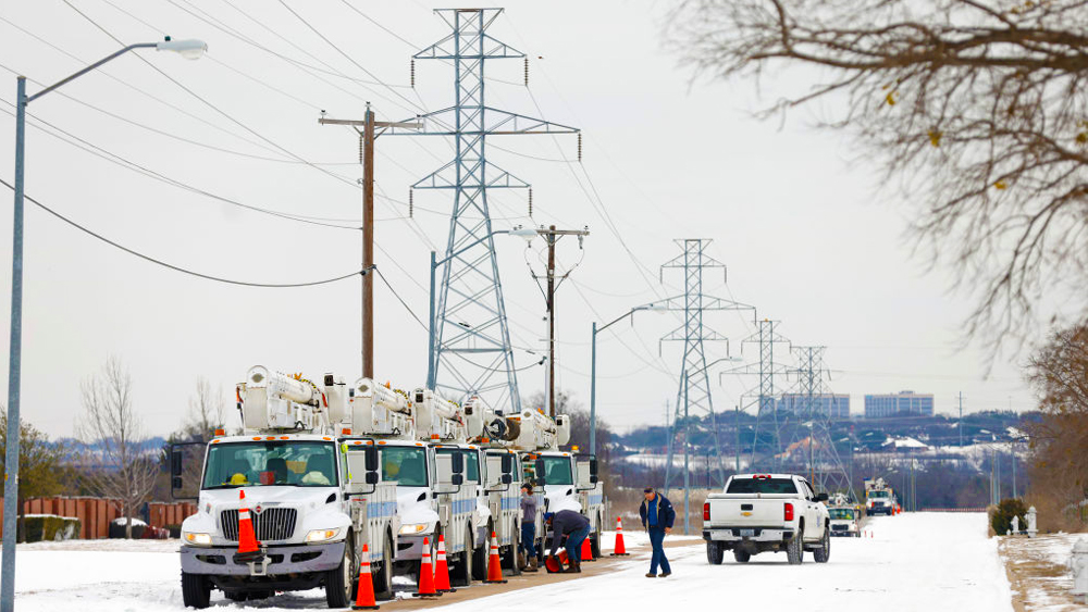 electric service trucks lined up at power lines in snow