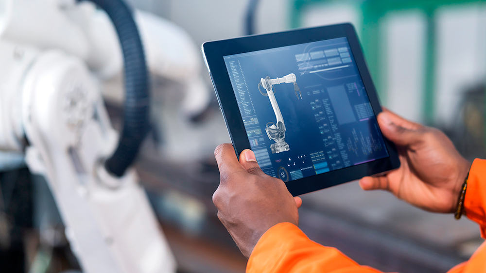 Engineer using a tablet to control an automated machine.