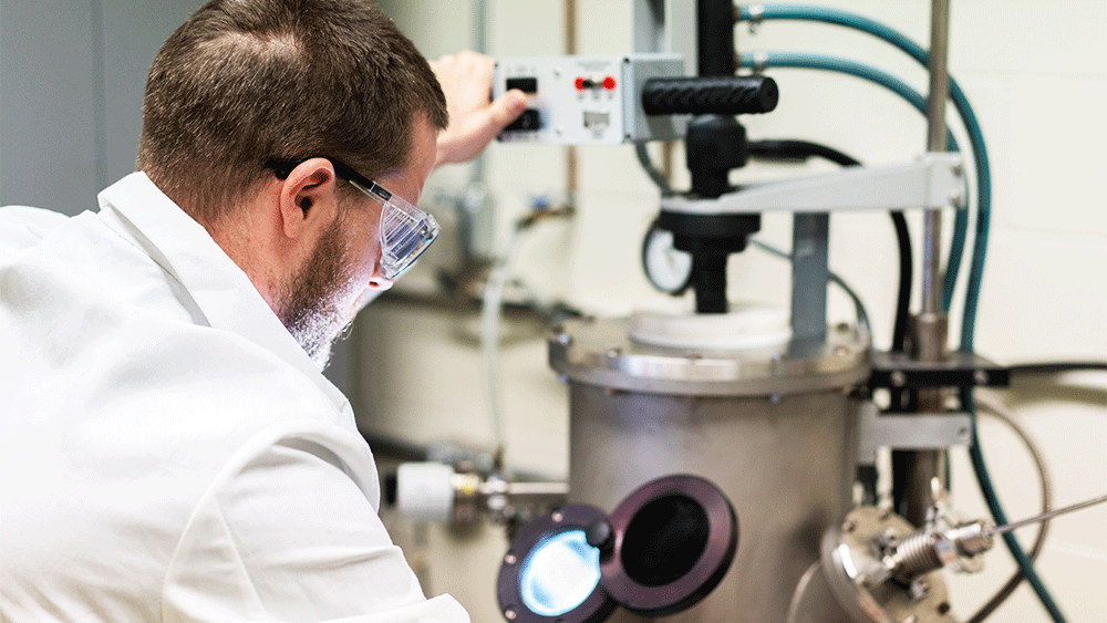 Doctoral student William Trehern operates a vacuum arc melter — a synthesis method commonly used to create high-purity alloys of various compositions