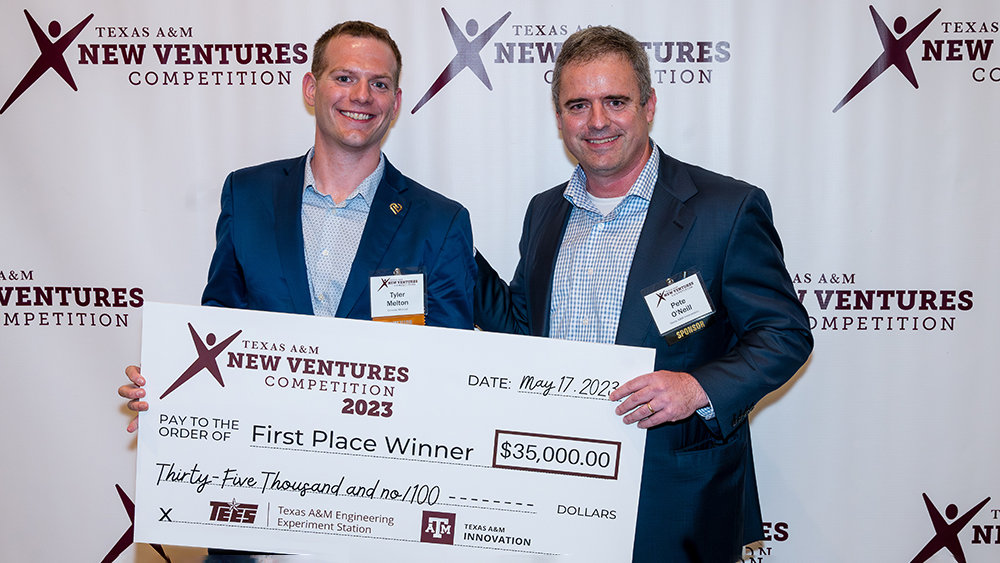 Tyler Melton (left) and Peter O'Neill (right) stand holding a large $35,000 check from the Texas A&amp;M New Ventures Competition for the first-place winner.
