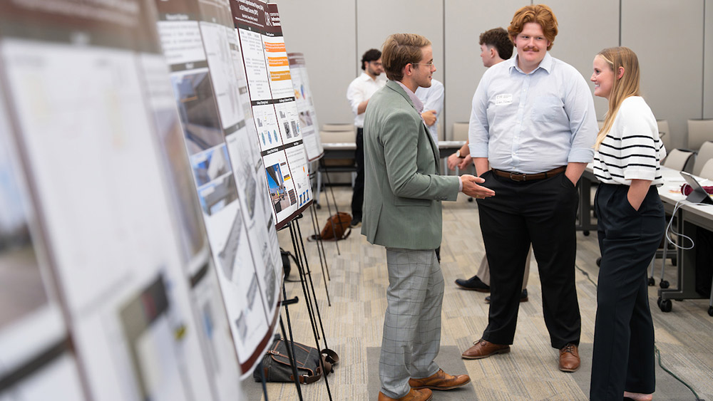 Student explaining his poster to industry members