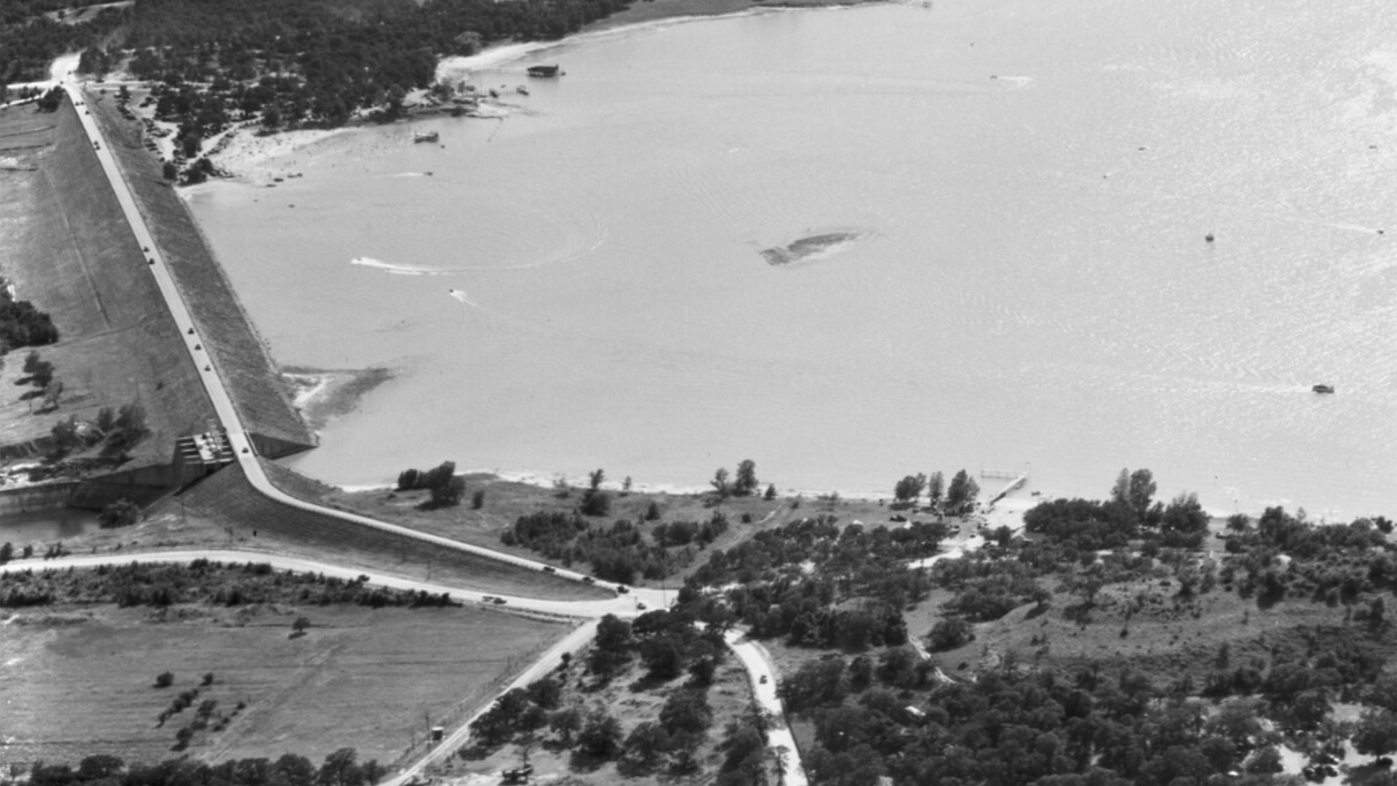 Black and white photo of a lake and damn