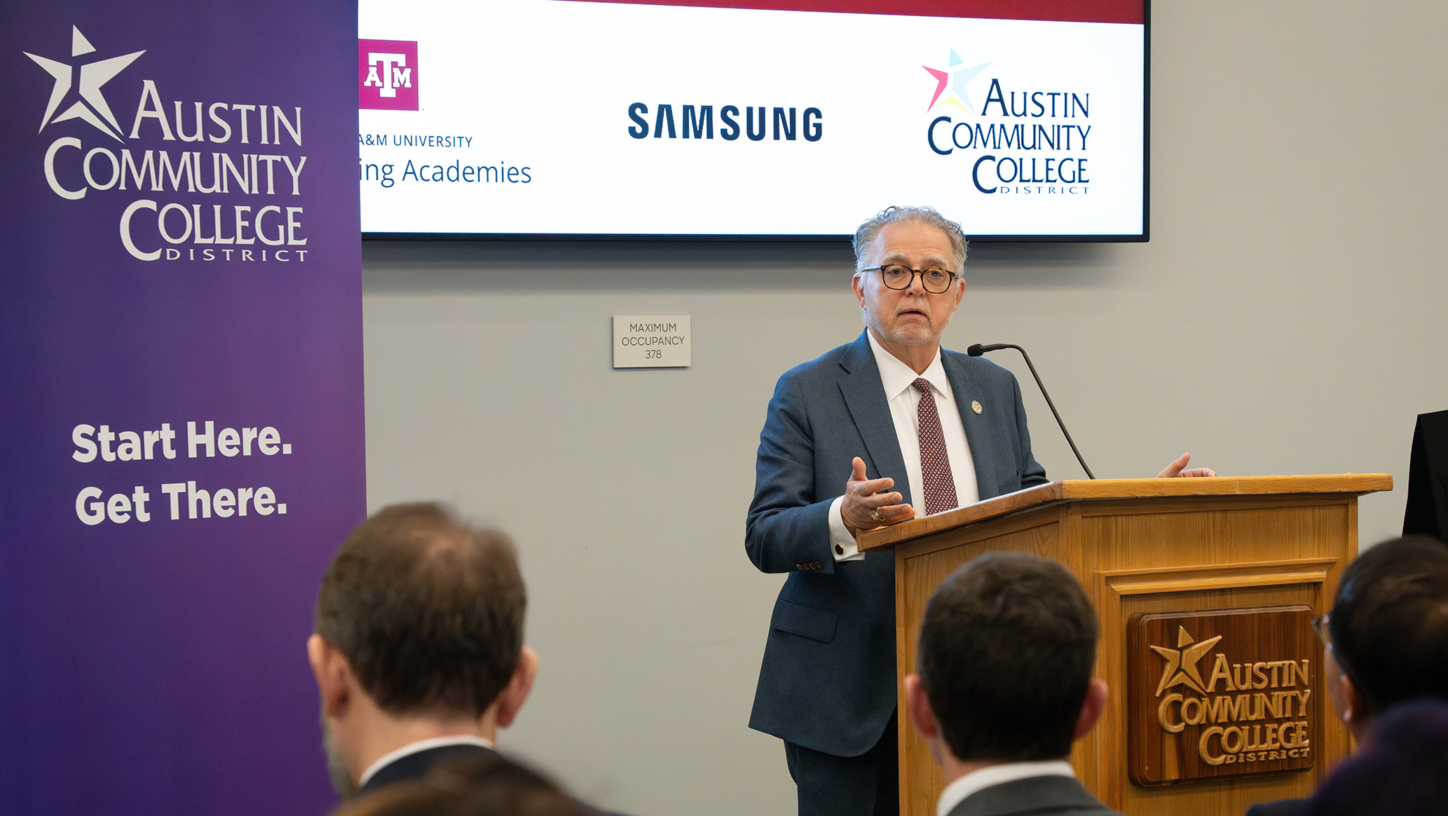 A man speaking behind a podium.